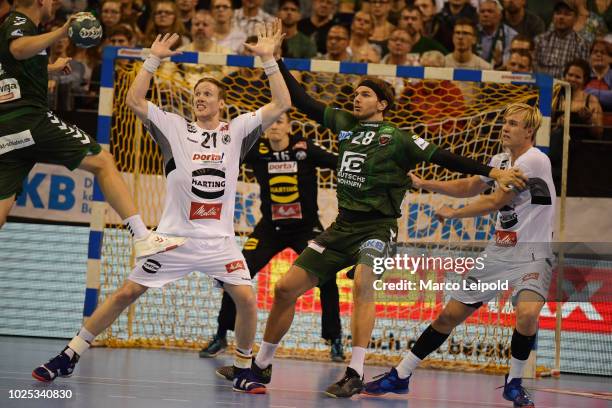 Magnus Gullerud of GWD Minden, Erik Schmidt of Fuechse Berlin and Marian Michalczik of GWD Minden during the game between Fuechse Berlin and GWD...