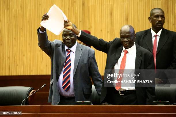 South Sudan's delegates celebrate after signing a peace deal to end their civil war, in Khartoum on August 30, 2018. - South Sudanese rebel chief...