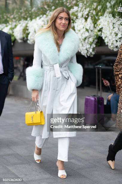 Emili Sindlev is seen on the street during Fashion Week Stockholm SS19 wearing light grey with light teal fur-trim coat with yellow YSL bag on August...