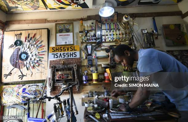 Kenyan "junk artist" Evans Ngure creates objects made with collected materials in his workshop in Nairobi on August 2, 2018. - In a room that is both...