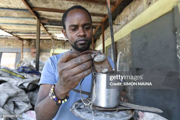 Kenyan "junk artist" Evans Ngure shows collected materials that he uses for his works at a dumpsite in Nairobi on August 2, 2018. - In a room that is...