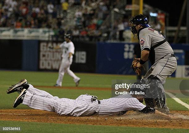 Jorge Cantu of the Florida Marlins scores the winning run off of a hit by Dan Uggla as Rod Barajas of the New York Mets is late with the tag in the...