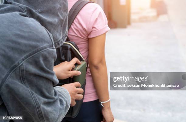 close-up of a person stealing purse from handbag - pickpocket foto e immagini stock