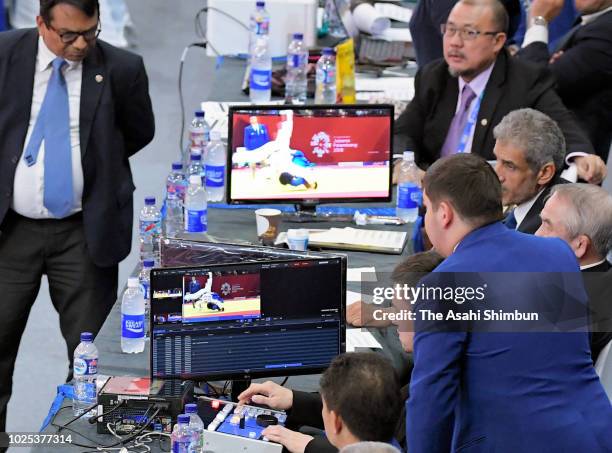 Judges check a monitor while Shohei Ono of Japan and An Changrim of South Korea competing in the Judo Men's -73kg final at the Jakarta Convention...