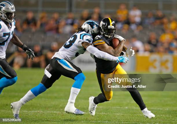 Stevan Ridley of the Pittsburgh Steelers rushes against LaDarius Gunter of the Carolina Panthers during a preseason game on August 30, 2018 at Heinz...