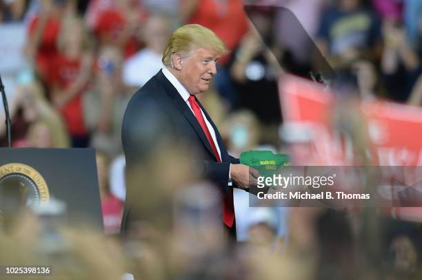 President Donald Trump tosses hats to the crowd at a campaign rally at the Ford Center on August 30, 2018 in Evansville, Indiana. The president was...