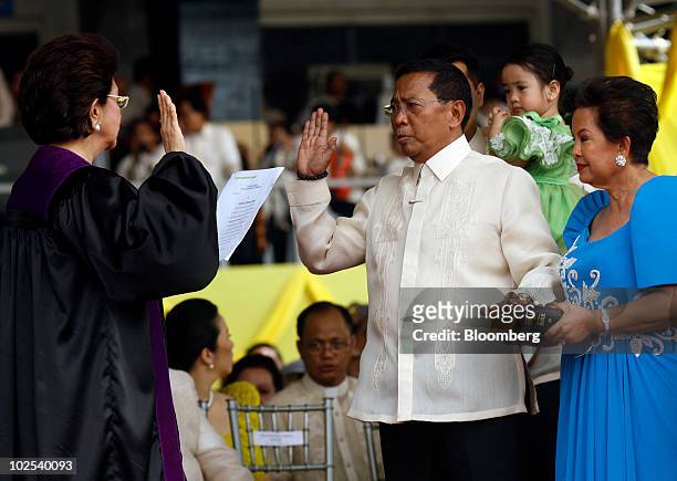 Jejomar Binay, Philippine vice president, center, is sworn in by Associate Justice Conchita Carpio Morales, left, at Quirino Grandstand in Manila,...