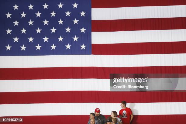 Attendees wait in front of an American flag at a rally with U.S. President Donald Trump in Evansville, Indiana, U.S., on Thursday, Aug. 30, 2018....