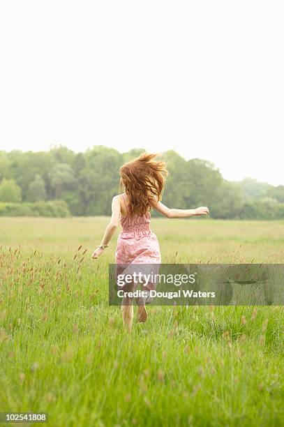 woman running through meadow. - man barefoot stock-fotos und bilder