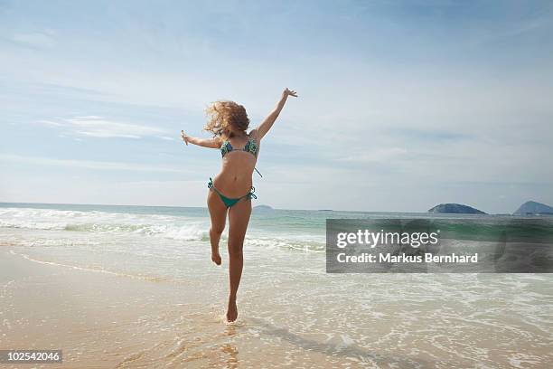 young woman skips a wave. - ipanema beach imagens e fotografias de stock