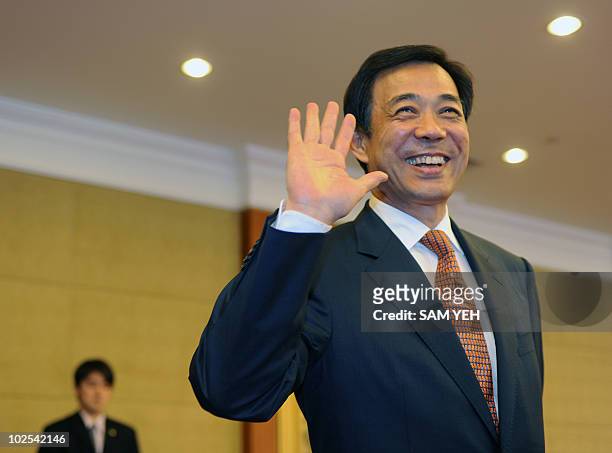 Bo Xilai, Secretary of Chongqing Municipal Committee of the Communist Party of China, waves to journalists after the Taiwan and China's trade talks...