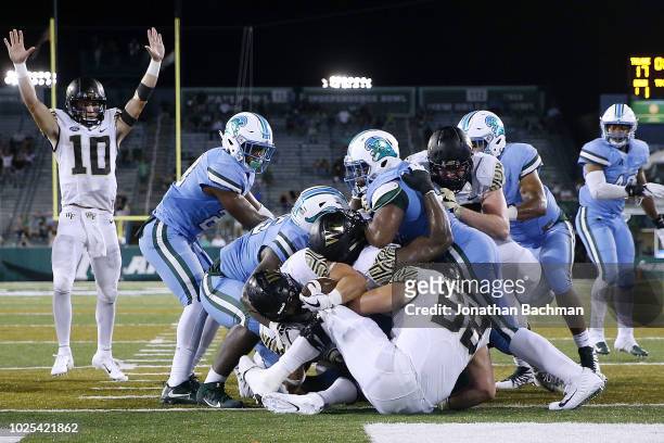 Cade Carney of the Wake Forest Demon Deacons scores a game-winning touchdown during overtime against the Tulane Green Wave on August 30, 2018 in New...