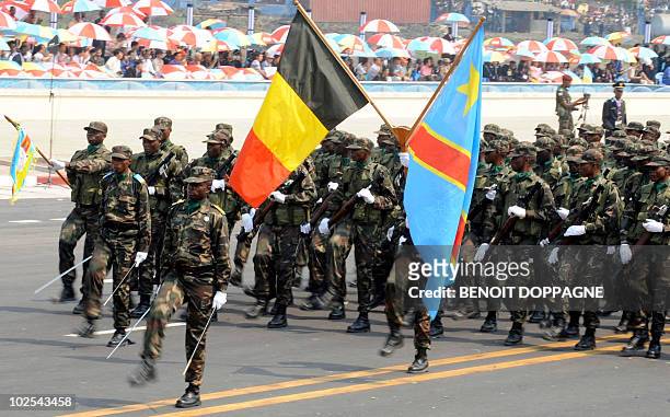 Congolese soldiers, holding a Belgian and a Congolese flags, take part in a military parade, in Kinshasa, on June 30 on the day of the country's 50th...