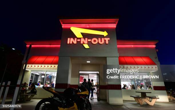 People enter an In-N-Out Burger restaurant in Alhambra, California, on August 30, 2018. - California's Democratic Party Chairman, Eric Bauman, is...
