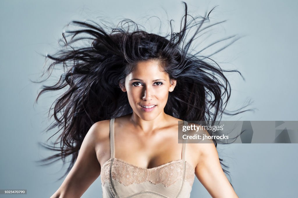 Young woman with beautiful black wind-blown hair