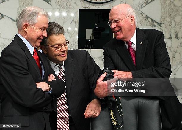 Committee Chairman U.S. U.S. Sen. Patrick Leahy shows U.S. Sen. Jeff Sessions and U.S. Sen. Al Franken photos he has taken on his camera during a...