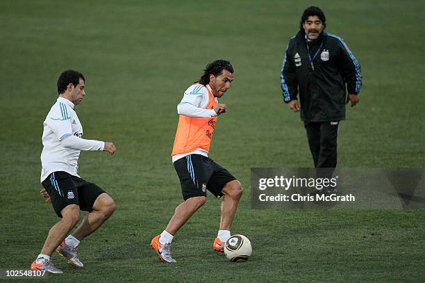 Argentina's head coach Diego Maradona watches on as Carlos Tevez keeps the ball away from Javier Mascherano during a team training session on June...