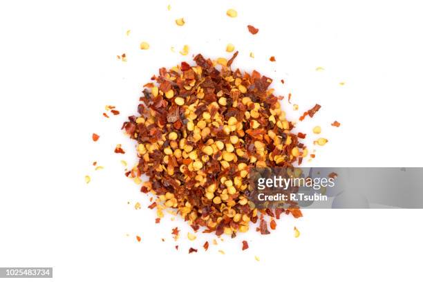the pile of a crushed red pepper, dried chili flakes and seeds isolated on white background - chili freisteller stock-fotos und bilder
