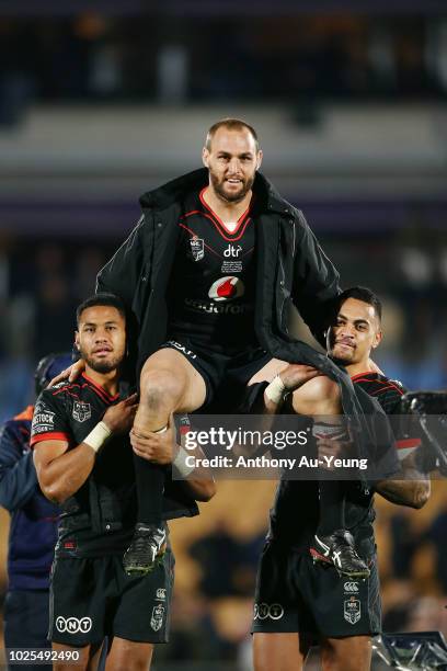 Simon Mannering of the Warriors is lifted up by his teammates David Fusitu'a and Ken Maumalo as he comes off the field after winning in his 300th...