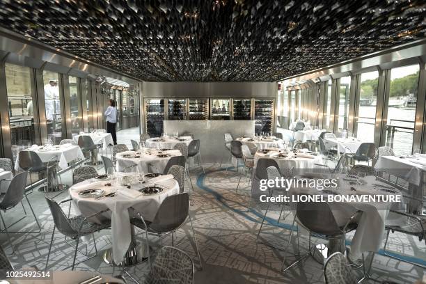 Dressed tables are seen at Alain Ducasse's new boat restaurant, the "Ducasse sur Seine", on August 30, 2018 in Paris. - Still smarting from being...