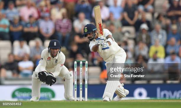 India batsman Virat Kohli picks up some runs watched by Jos Buttler during day two of the 4th Specsavers Test match between England and India at The...