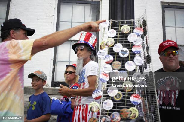Vendor sells buttons as attendees arrive for a rally with U.S. President Donald Trump in Evansville, Indiana, U.S., on Thursday, Aug. 30, 2018. Trump...