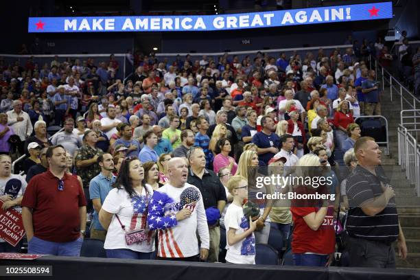 Attendees say the pledge of allegiance during a rally with U.S. President Donald Trump in Evansville, Indiana, U.S., on Thursday, Aug. 30, 2018....