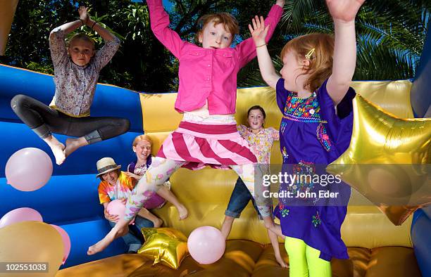 kids play in moon bounce - bouncy castle stock pictures, royalty-free photos & images