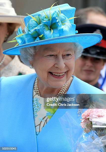 Queen Elizabeth II is given flowers by children as she visits the Canadian Museum of Nature on June 30, 2010 in Ottawa, Canada. The Queen and Duke of...