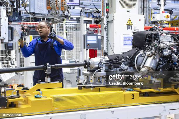 Worker assembles parts to be used in the engine of a BMW AG X3 sport utility vehicles on the production line at the BMW South Africa Pty Ltd. Rosslyn...