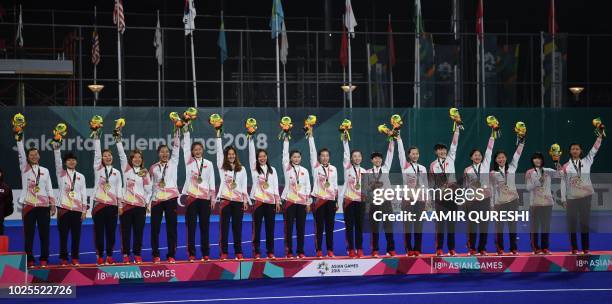 China's bronze medallista pose on the podium during the medals ceremony for the women's field hockey final match between India and Japan at the 2018...