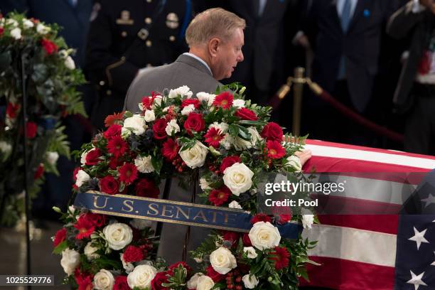 Senatot Lindsey Graham pays his respects to the flag-draped casket bearing the remains of John McCain, who lived and worked in Congress over four...