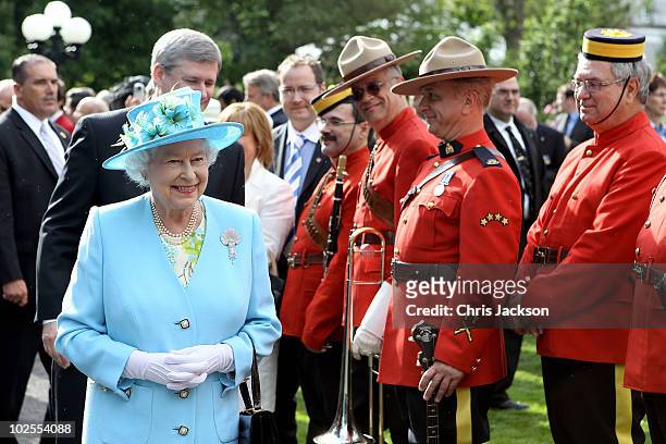 Queen Elizabeth II is followed by Prime minister Stephen Harper as she attends a garden party at Government House on June 30, 2010 in Ottawa, Canada....