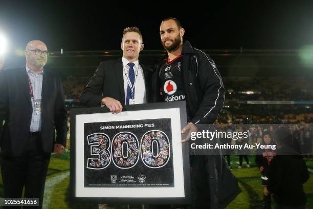 Simon Mannering of the Warriors is presented with a framed print from former Warriors teammate Michael Luck after winning in his 300th match and the...