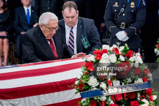 Former Secretary of State Henry Kissinger touches the casket of Sen. John McCain, R-Ariz., as he lies in state in the Rotunda of the U.S. Capitol, on...