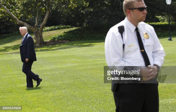 President Donald Trump walks behind a Secret Service officer on the South Lawn of the White House before boarding Marine One in Washington, D.C.,...