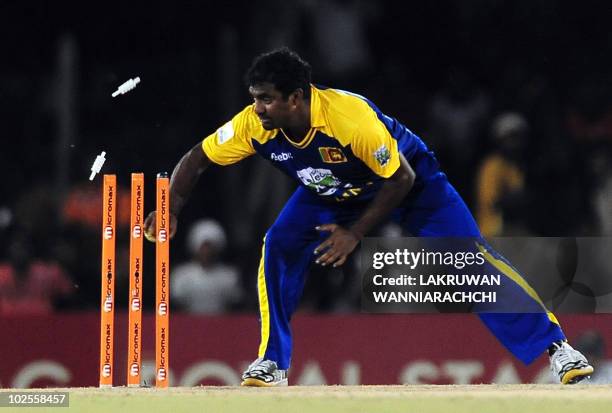 Sri Lankan cricketer Muttiah Muralitharan breaks the wicket as he runs out unseen Pakistan cricketer Kamran Akmal during the first One Day...