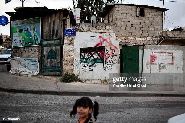 Palestinian girl walks the street in east Jerusalem's Sheikh Jarrah neighborhood, where some houses in the Arab neighborhood have been occupied by...