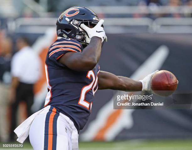 Tarik Cohen of the Chicago Bears covers his eyes as he plays one-handed catch during warm-ups before a preseason game against the Buffalo Bills at...