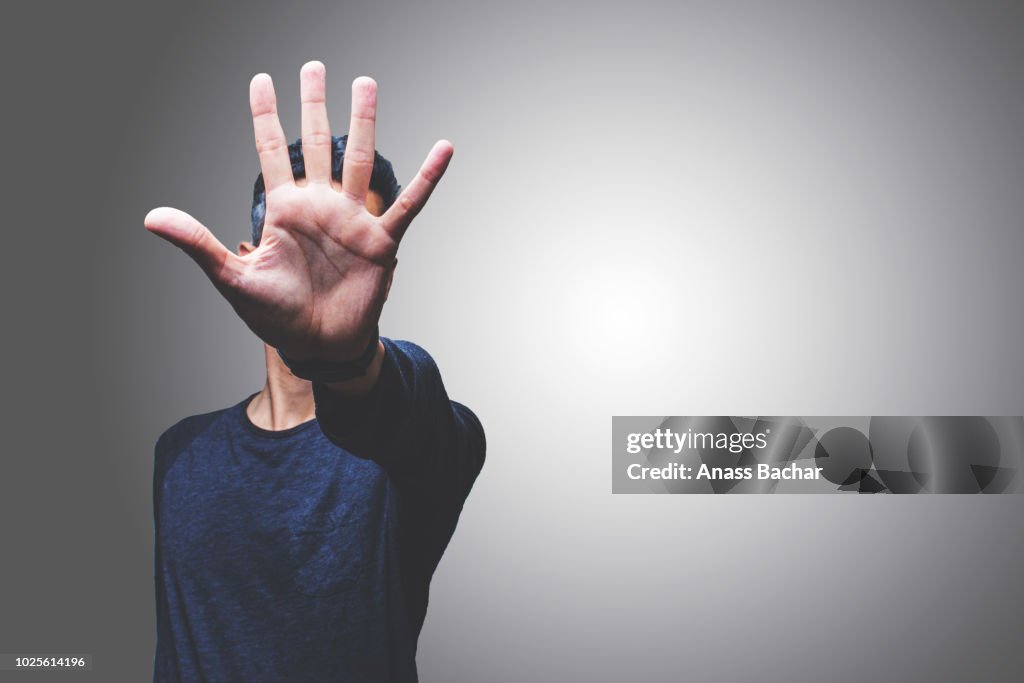 Mid Adult Man Gesturing While Standing Against Gray Background
