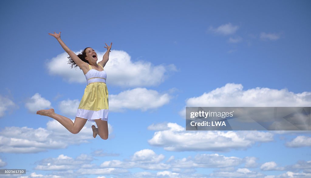 Excited Woman Jumping, Arms Raised In Air