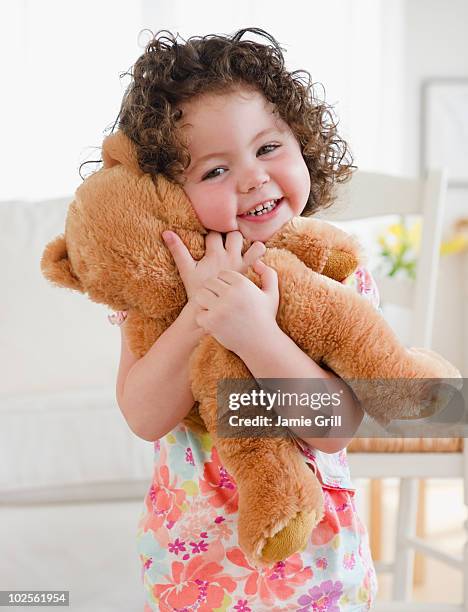 toddler hugging teddy bear, smiling - stofftier stock-fotos und bilder