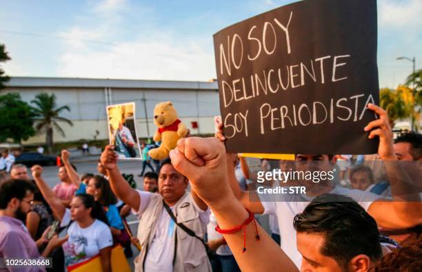 Man holds a sign reading "I'm not a criminal, I'm a journalist" during a protest for the murder of Mexican journalist Javier Enrique Rodriguez...