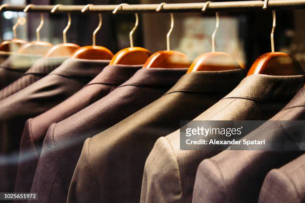 men suits hanging on a rack, close up - upper class stock pictures, royalty-free photos & images