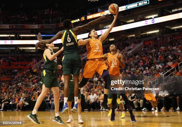 Diana Taurasi of the Phoenix Mercury lays up a shot past Natasha Howard of the Seattle Storm during game three of the WNBA Western Conference Finals...