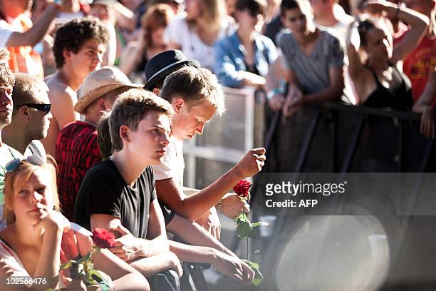 Fanpay their respect during the performance of American rock legend Patti Smith in Roskilde on July 1, 2010 in memory of the nine people who passed...