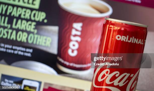 Bottle of Coca Cola is seen near a screen displaying Costa Cafe logo on a screen in Ankara, Turkey on September 1, 2018.