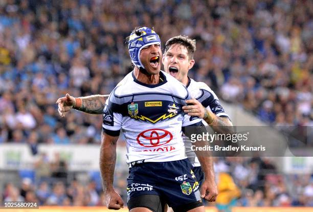 Johnathan Thurston of the Cowboys celebrates a try by team mate Gavin Cooper during the round 25 NRL match between the Gold Coast Titans and the...