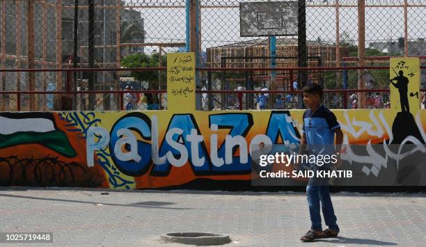 Palestinian school boy walks past a UN Relief and Works Agency's school in the Rafah refugee camp, southern Gaza Strip, on September 1, 2018. The...