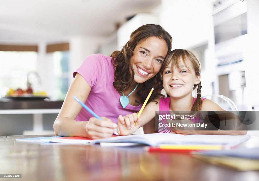 Mother helping daughter (8-9) with homework